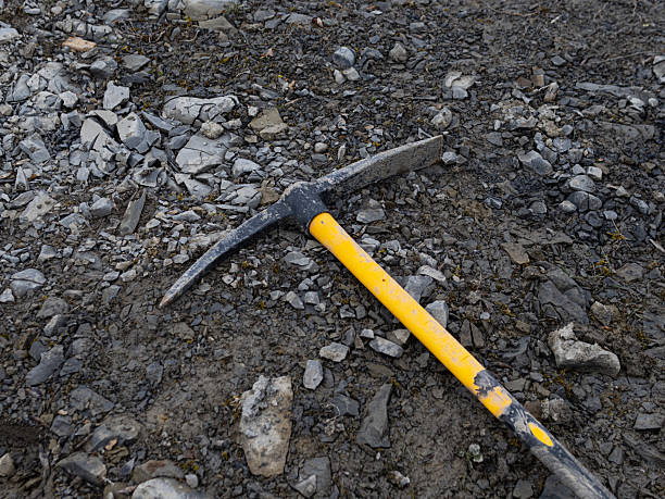 istock pickaxe on stones. Construction tool on a job site 2211027070