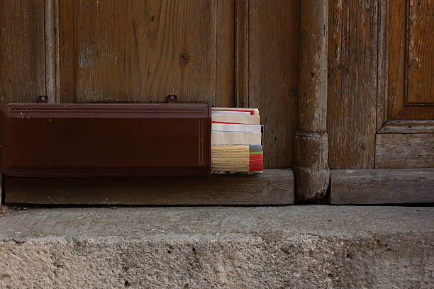 Rustic wooden door with an open mailbox and overflowing letters.