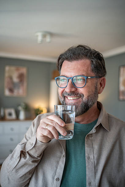 istock Happy mature man drinking fresh water at home 2211033422
