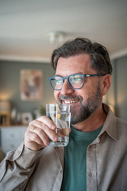 istock Smiling bearded man drinking water at home 2211033424