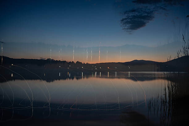 Boy playing throwing stones into a lake in winter