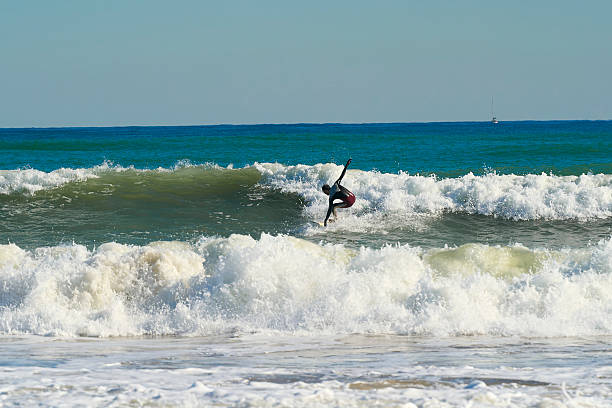 istock Young male surfer surfing wave in blue sea 2211036522