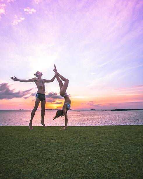 istock Male is doing dancer pose while holding female in soft handstand position. 2211037659