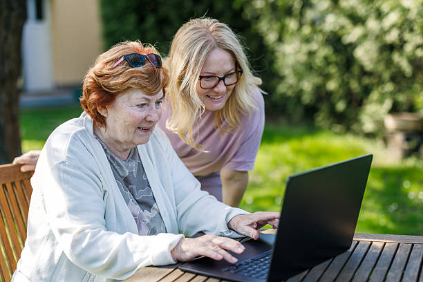 istock Two smiling mature and senior women are using laptop at backyard 2211038283