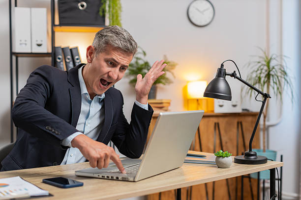 istock Frustrated Caucasian young entrepreneur having software problems with laptop at home office desk 2211058320