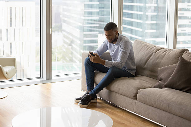 istock In luxury skyscraper penthouse young African man using smartphone 2211065660