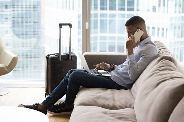 istock Businessman talks on cellphone seated on sofa with laptop 2211065691