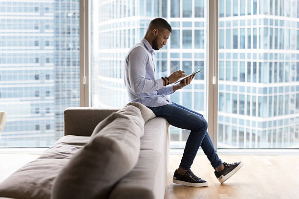 istock Busy African businessman work on digital tablet in modern apartment 2211065834