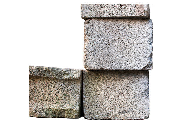Three concrete blocks stacked neatly, with rough gray textures. Two blocks are horizontal on the bottom, while a vertical block is placed on the top right. The scene highlights industrial practicality.