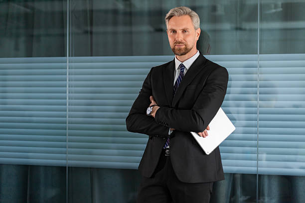 istock Smiling handsome businessman manager standing in office with tablet computer 2211074702
