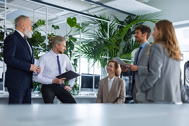 istock Business people discussing work together using a tablet and laptop taking notes in a modern office 2211074987