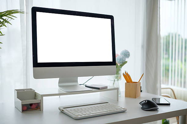 istock Well-lit home office featuring a stylish desk, an ergonomic setup, and decorative elements like flowers and stationery. 2211077196