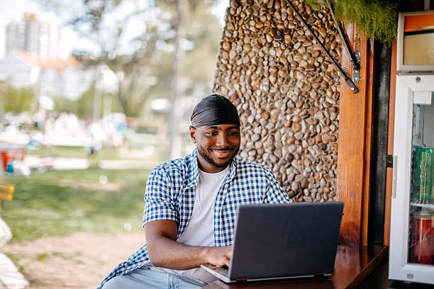 istock Young man spending time in outdoors cafe after work and using laptop 2211083943