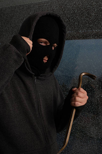 istock Aggressive Burglar Holding Crowbar and Pulling Hood. 2211085968