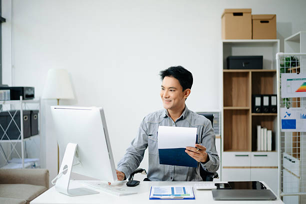 istock Asian businessman typing laptop and tablet Placed at the table 2211086978