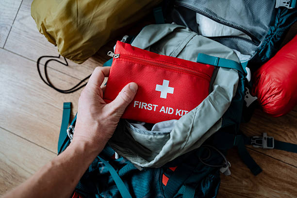 istock A single individual is carefully placing a first aid kit into a backpack, ensuring that they are wellprepared for any potential medical emergencies that might arise during their journey 2211090243