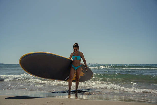 Female surfer is walking out of the sea after a morning of paddling