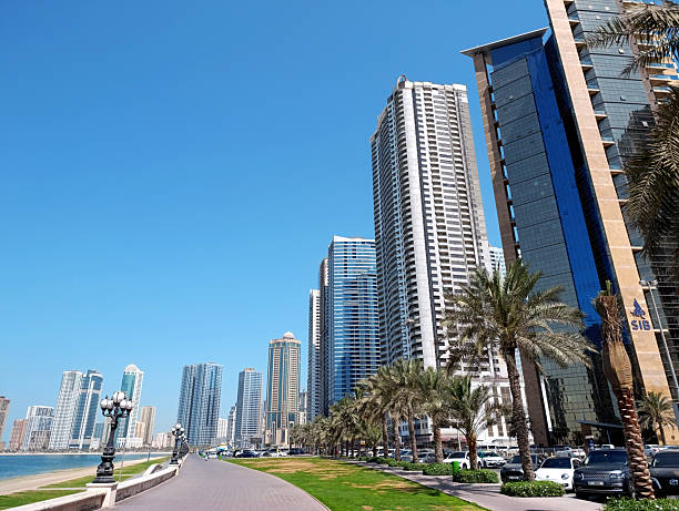 Riding taxi through the multilane road during rush house with view of tall office buildings during sunny day in Dubai, United Arab Emirates