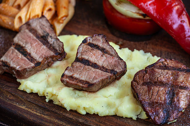 Steak with vegetables and peppers on a wooden Board.