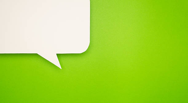 istock Close-up of a blank white speech bubble on a bright green background. 2211100702