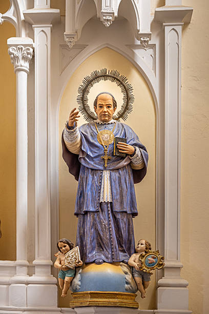 Hand of The Blessed Virgin Mary statue standing in front of the Roman Catholic Diocese with crucifix or cross and blue sky in the background at Chanthaburi Province, Thailand.