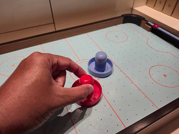 istock Hand Holding Red Pusher on Air Hockey Table 2211111336