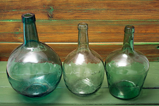 three bottles of green glass on a wooden background
