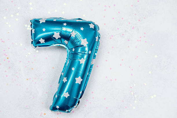 istock Bright blue balloon number seven with star patterns on a festive background 2211116060