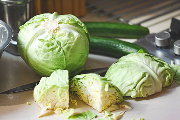 istock young white cabbage on the table, whole head and cut pieces 2211119470