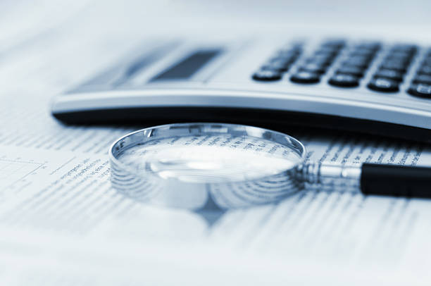 istock Magnifying glass and calculator on financial data 2211121026