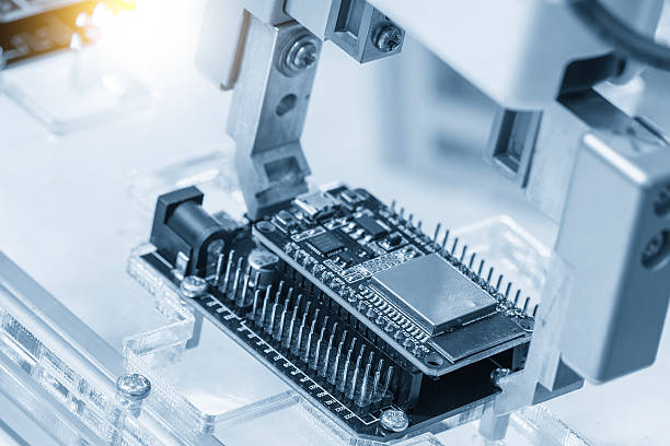 istock Close up scene the micro circuit board assembly process by robotic arm in the light blue scene. 2211121911