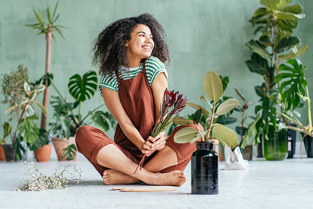 istock Young woman cultivating home plants 2211124990