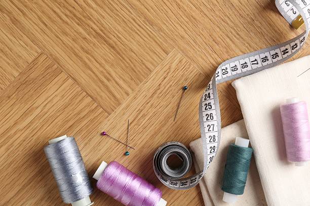 istock Sewing threads and other supplies on wooden table, flat lay. Space for text 2211125184