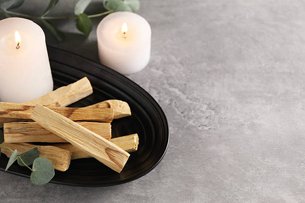 istock Palo santo sticks, eucalyptus branches and burning candles on grey table, closeup. Space for text 2211125675