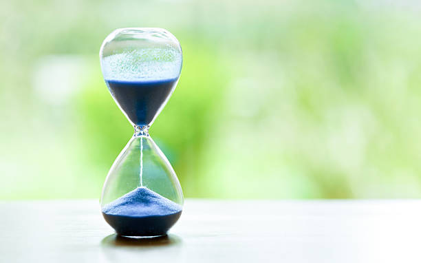 istock Hourglass with green blurred background and copy space 2211126521