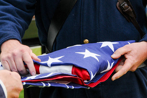 istock American flag folding ceremony on Memorial Day or Veterans Day 2211129357