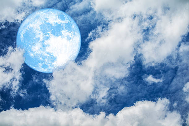 A captivating full moon radiates its bright light through delicate wispy clouds in a serene night sky. This atmospheric scene evokes a sense of tranquility and wonder.
