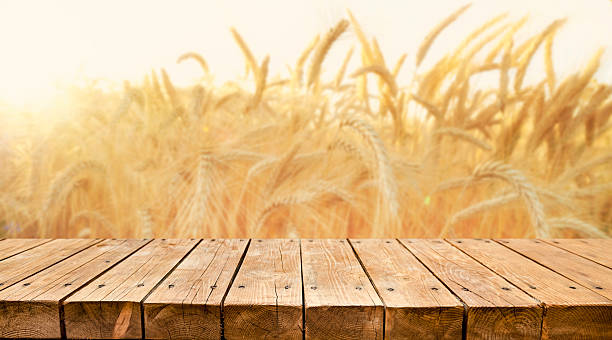 istock Empty wooden table with wheat in the background 2211130295