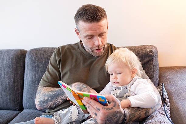 istock Father Reading a Book to Toddler on Couch 2211130814