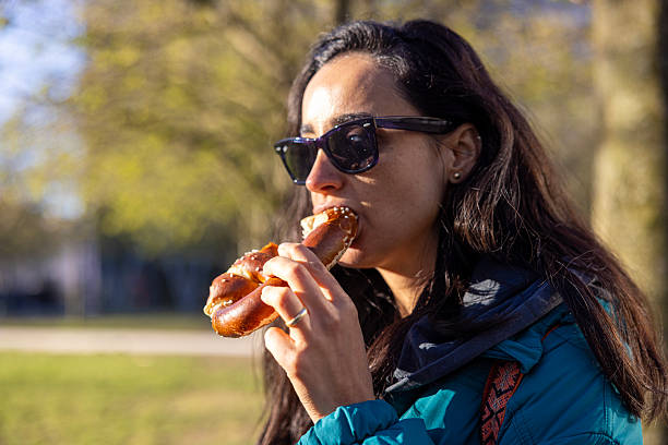 close up of woman eating a pretzel