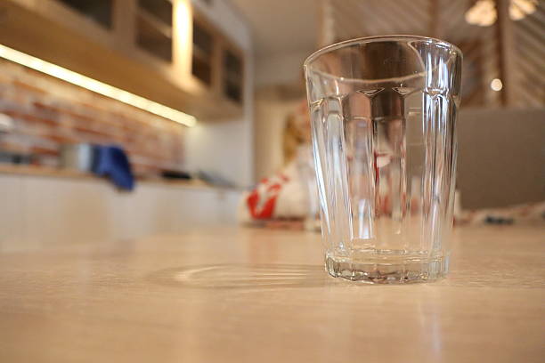 A clear empty glass placed on a minimalistic table, beautifully showcasing a contemporary interior design style
