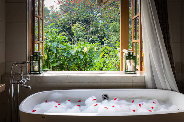 istock Soaking Tub with View of Lush Garden Through Open Window 2211132628