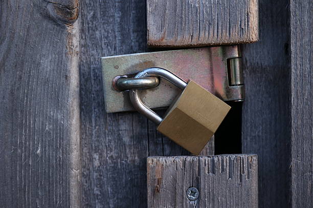 istock A gold padlock is hanging from a wooden door 2211133352