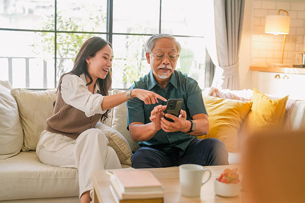 istock Asian senior father takes help in his smartphone, regarding a new application based on the latest technology Young woman daughter teach help in smartphone apllication use 2211134807