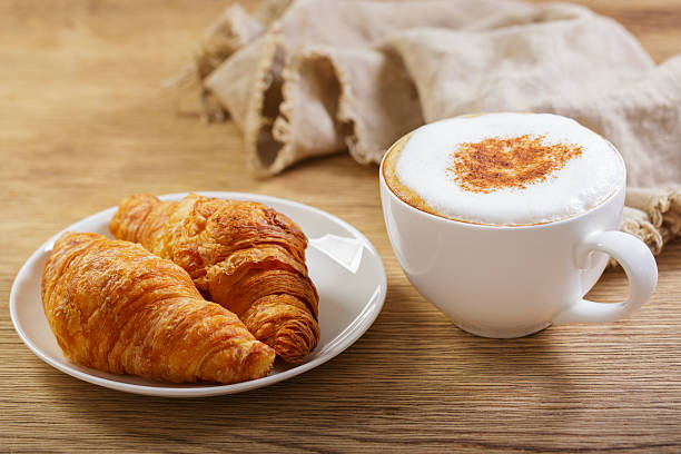istock Cup of cappuccino coffee with croissants 2211135068