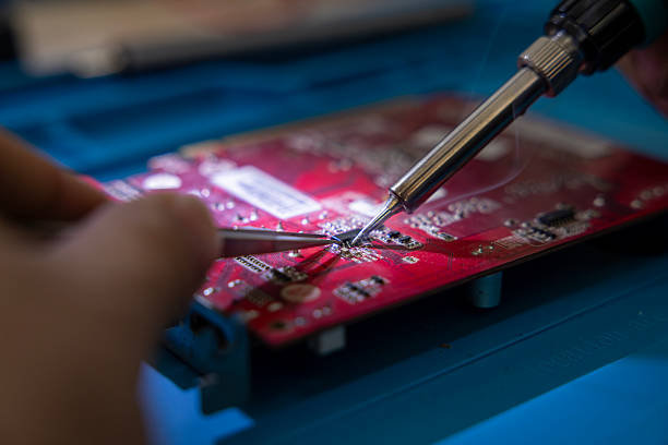 Technician soldering a mother board