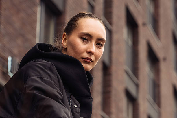 istock Young woman looking pensive at camera, reflecting a serious mood and contemplative expression in an outdoor urban environment, suggesting thoughtfulness and introspection 2211138987