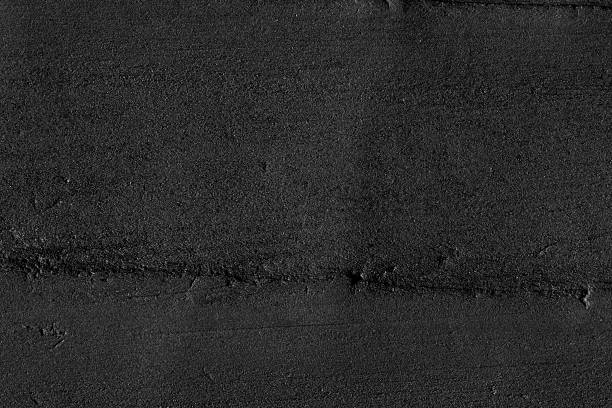 High angle view of a flat textured wooden board backgrounds. It burnt and black colored with fire skill. It is carbonization the surface. It has a beautiful nature and abstractive pattern. A close-up studio shooting shows details and lots of wood grain on the wood table. The piece of wood at the surface of the table also appears rich wooden material on it. The wood is black and pattern on the bottom. Flat lay style. It's high-resolution textured quality. The close-up gives a direct view on the table, showing cracks and knotholes in the wood.