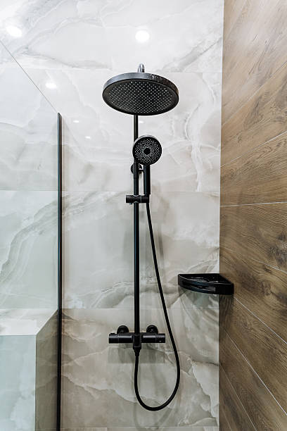 istock In a stylish bathroom, a sleek black shower head is hanging elegantly adjacent to a beautifully crafted wooden wall, creating a striking contrast and enhancing the overall decor 2211143039
