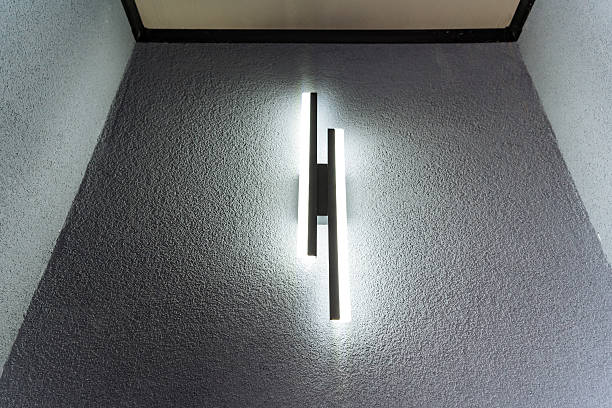 In the corner of the room, there is a light source illuminating the wall, casting a gentle glow, enhancing the ambiance and creating a contrast with the grey and silver shadows
